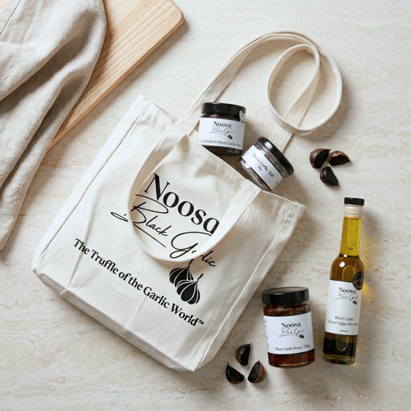Noosa Black Garlic tote bag filled with gourmet black garlic products including oil, paste, honey and vinegar.