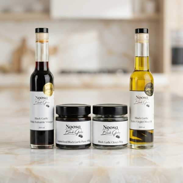 Collection of Noosa Black Garlic products on a kitchen counter.
